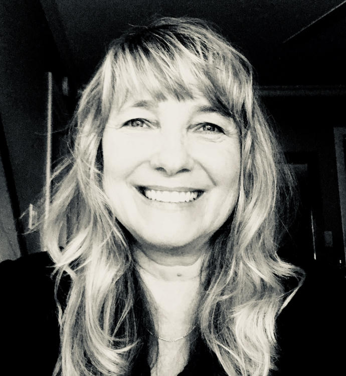 Black and white portrait of a smiling woman with wavy hair.